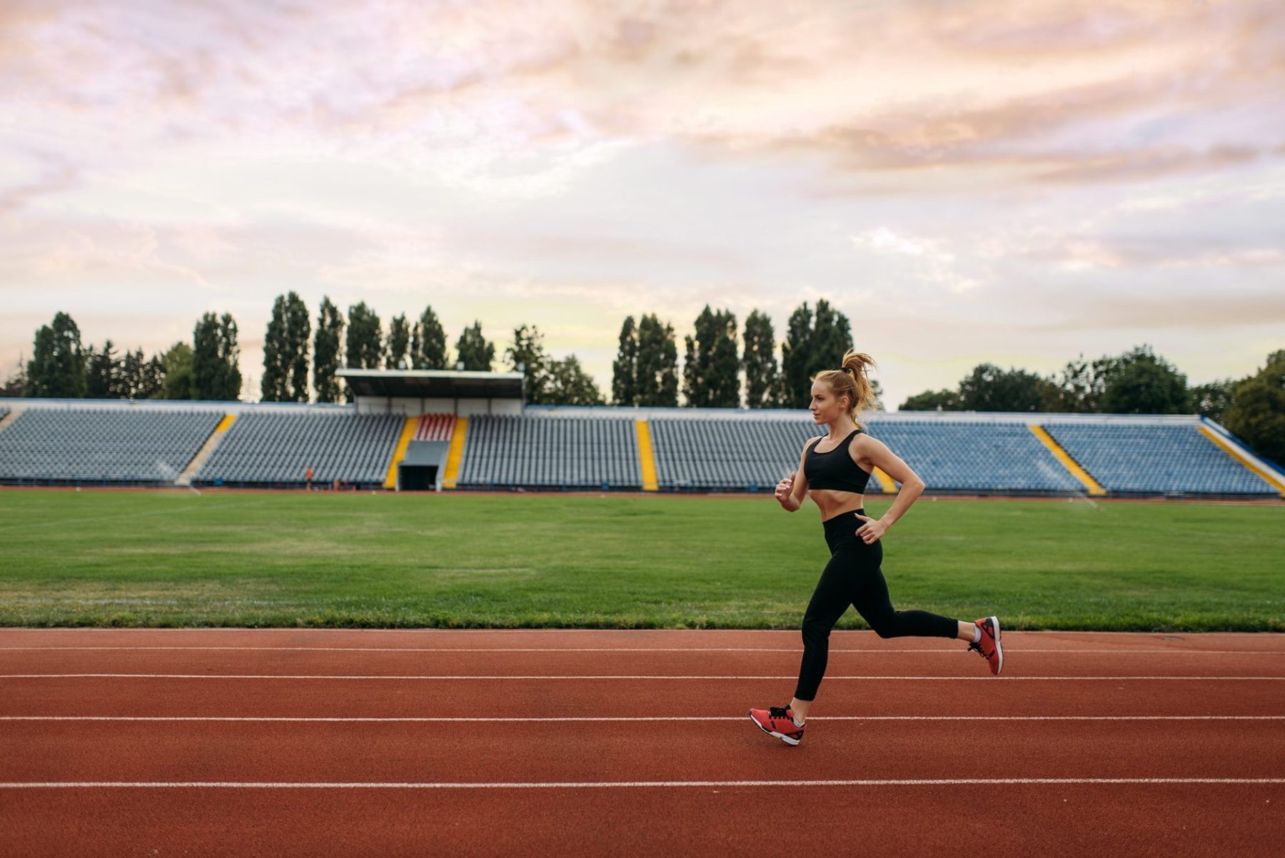 Female runner jogging, training on stadium